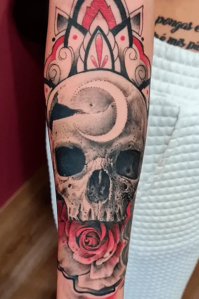 Tatuaje de calavera con rosa en el brazo, negro y rojo